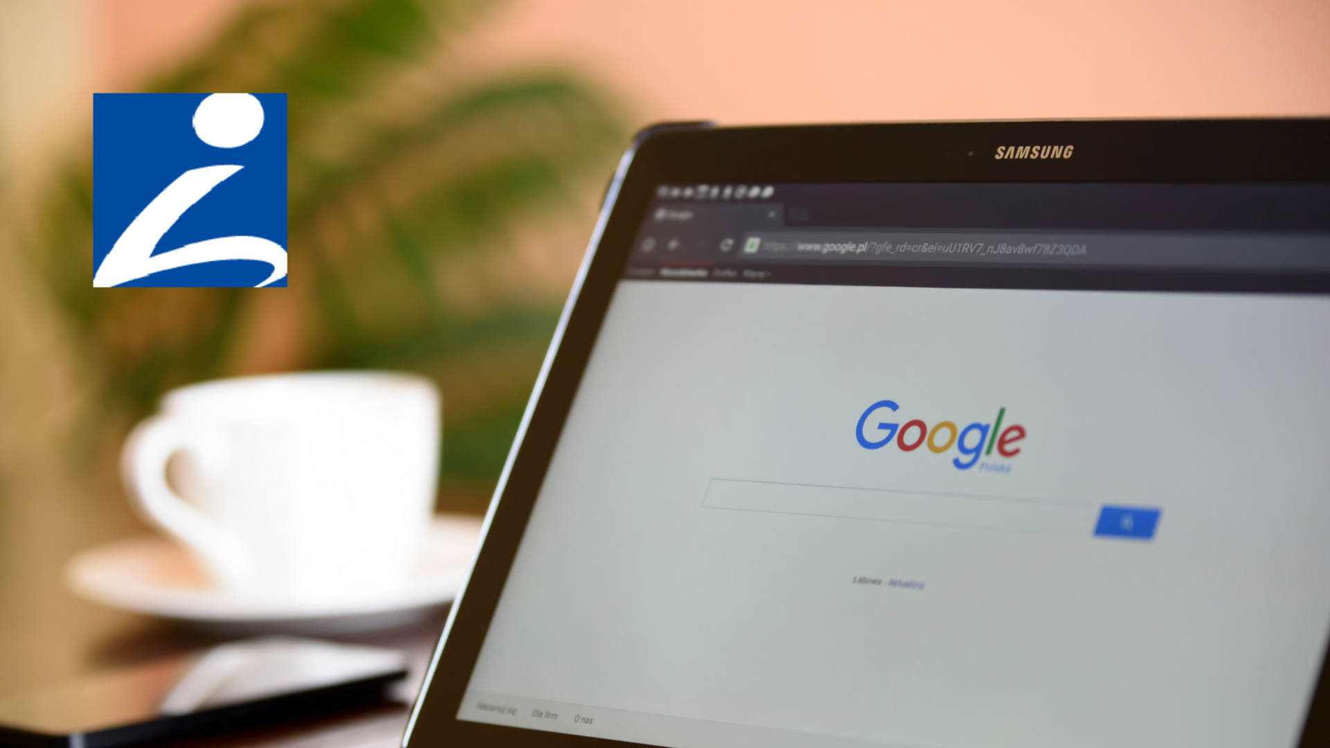Tablet showing Google homepage on a desk beside a coffee cup and plant.