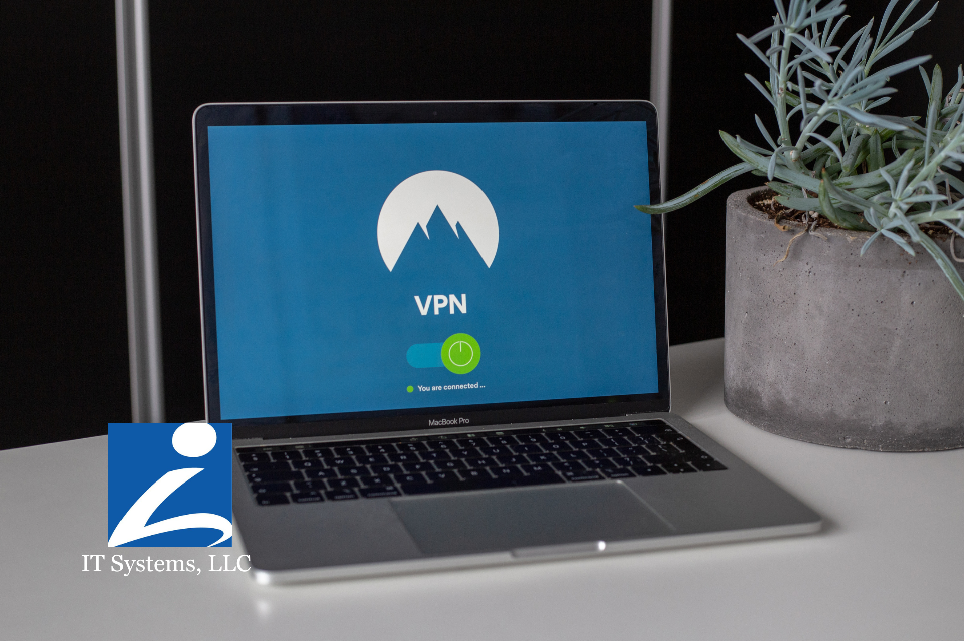 A laptop showing a VPN application screen sits on a white desk next to a potted plant, with a company logo in the corner.