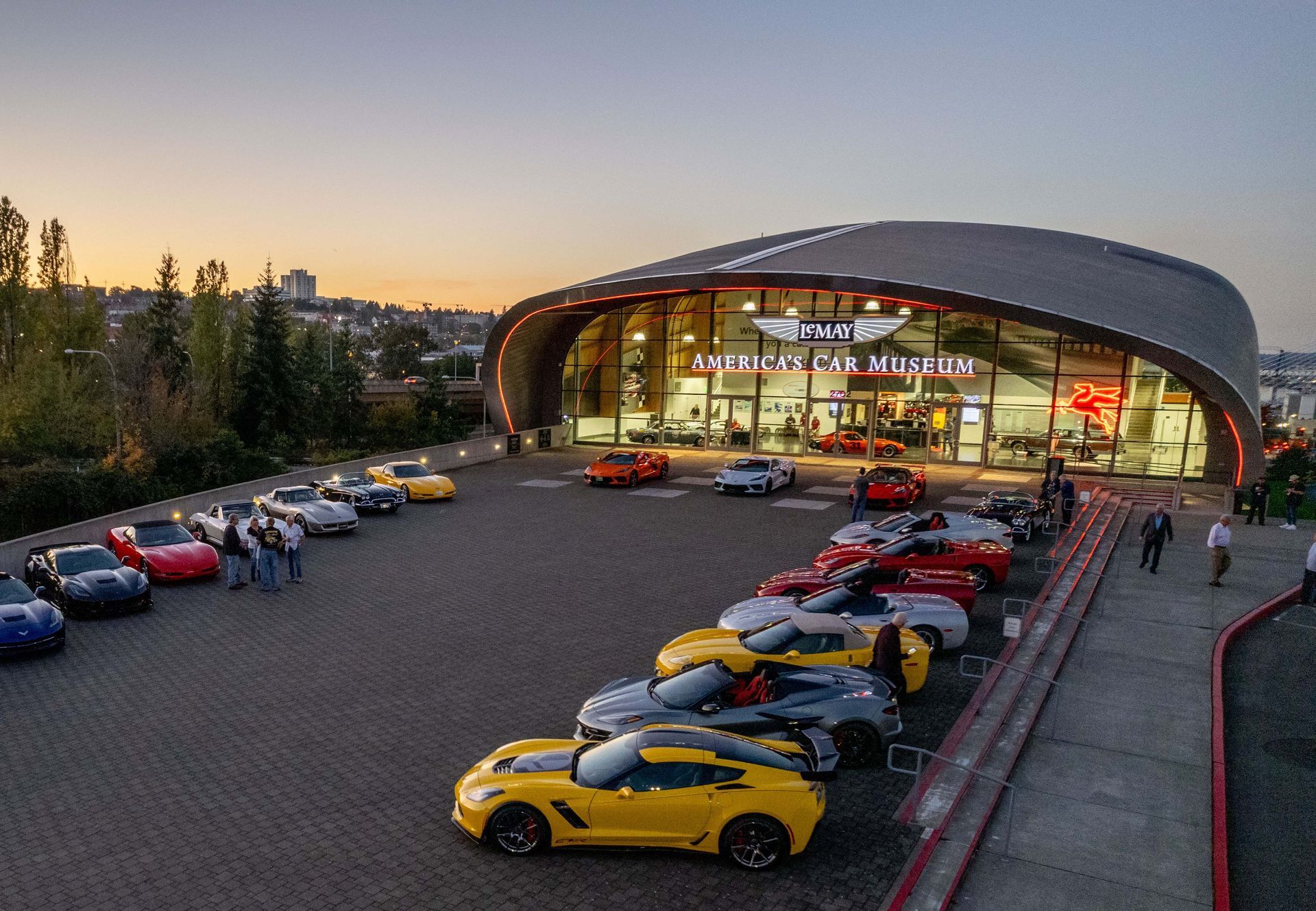 A group of cars are parked in front of a building.