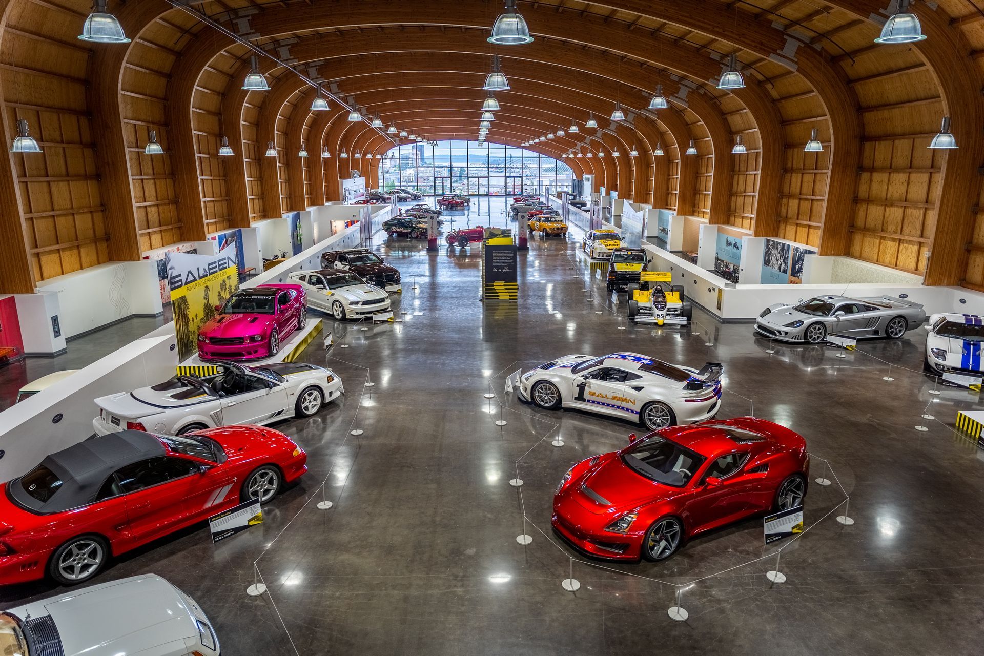 A lot of cars are parked inside of a building.