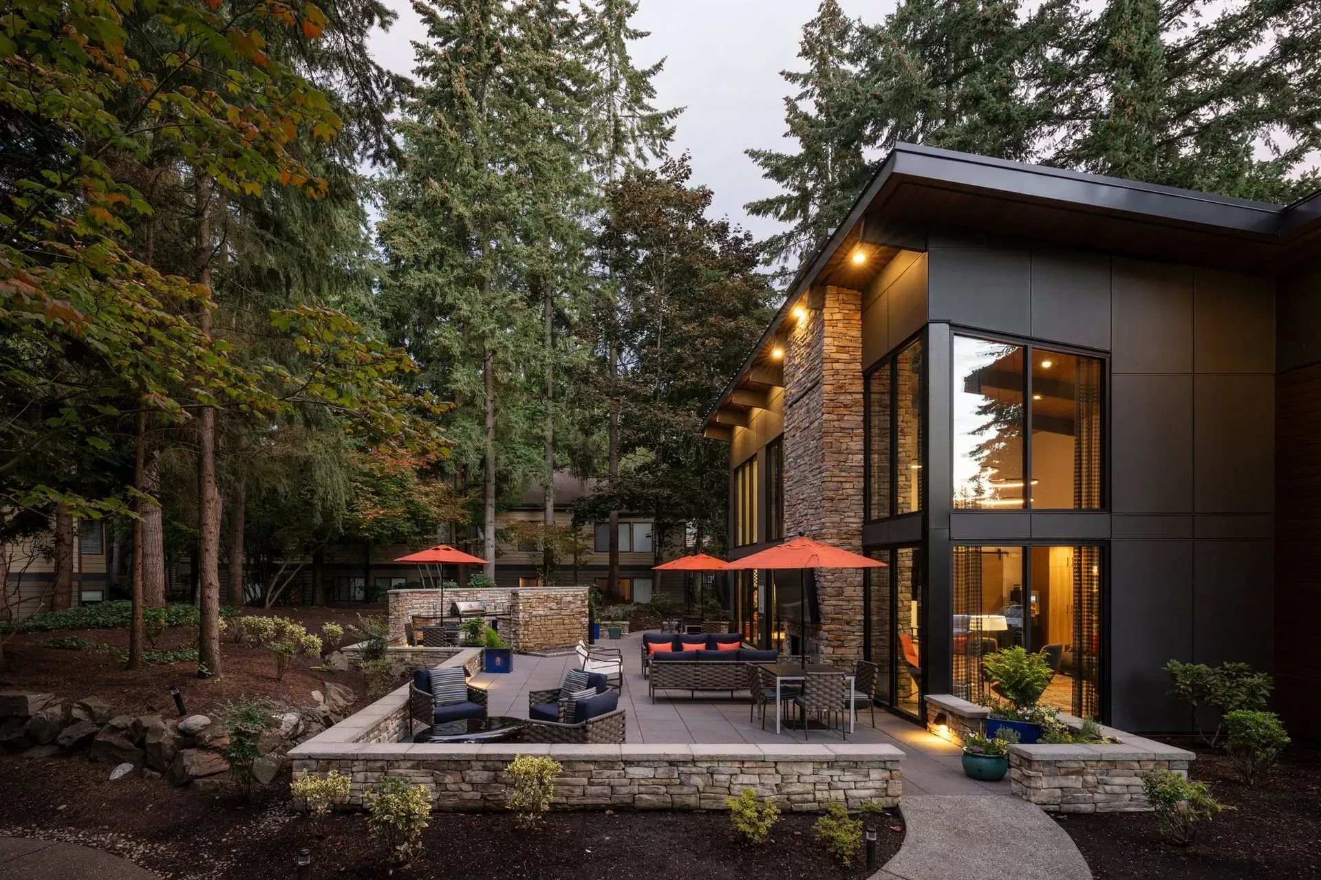 Modern apartment community exterior at Park Bellevue with patio, trees, and orange umbrellas.