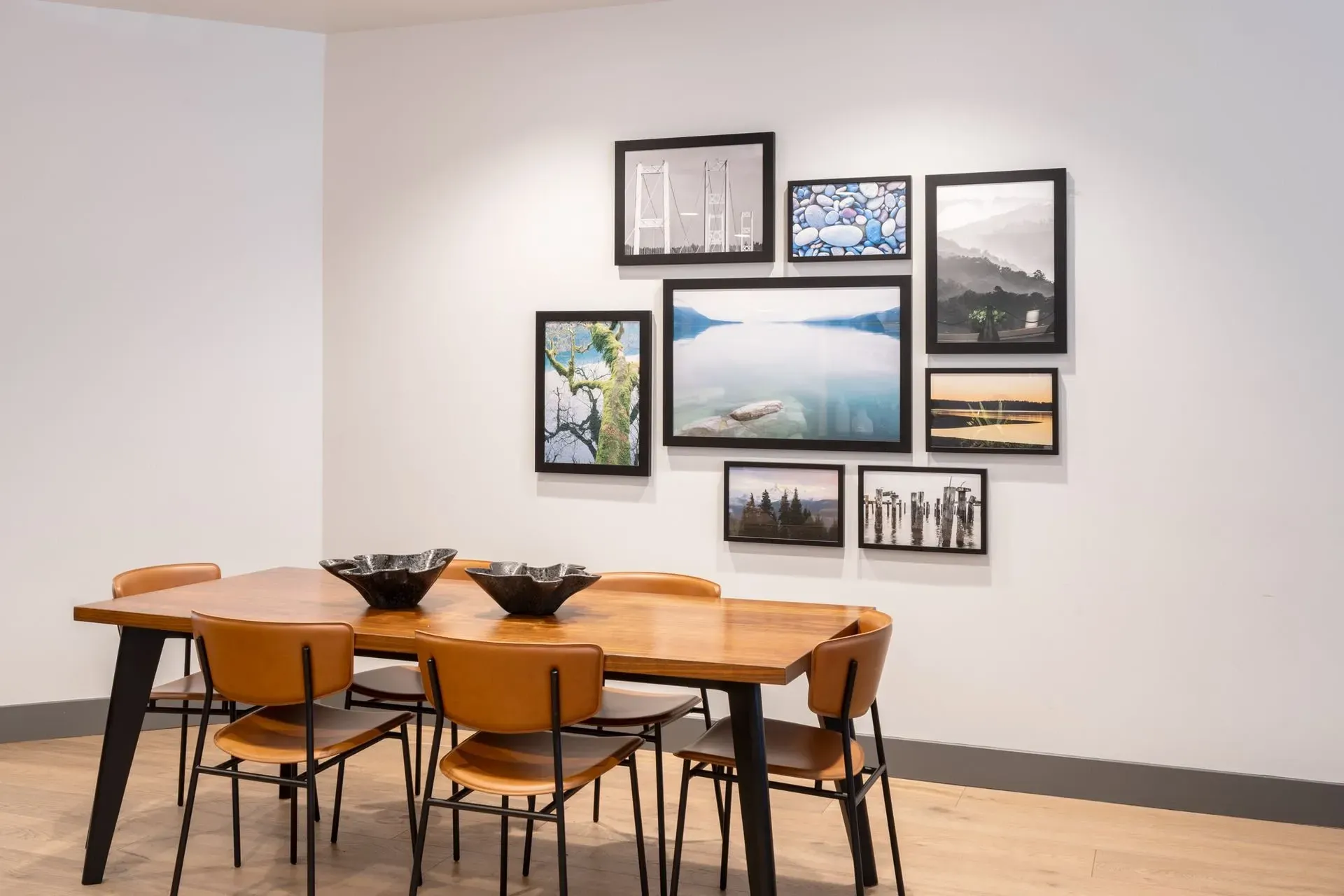 Park Bellevue apartment community resident area with a wooden table, six chairs, and a gallery wall of framed photos.