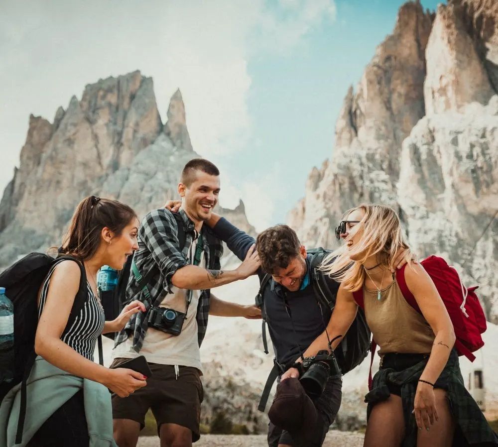 A group of people are standing next to each other in front of a mountain.