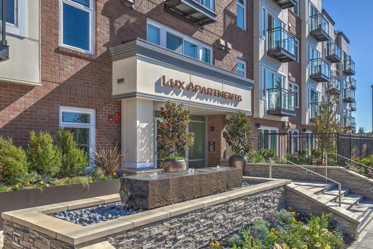 A large apartment building with a fountain in front of it.