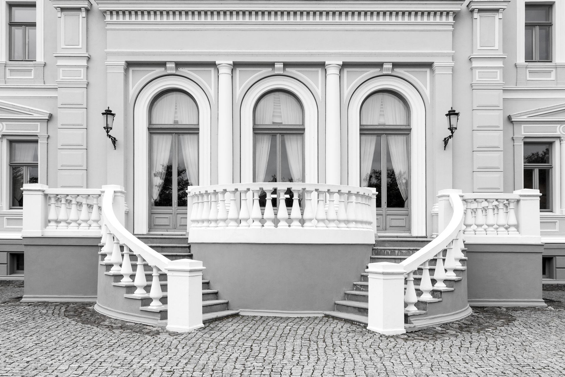 Une photo en noir et blanc d'un grand bâtiment avec des escaliers et un balcon.
