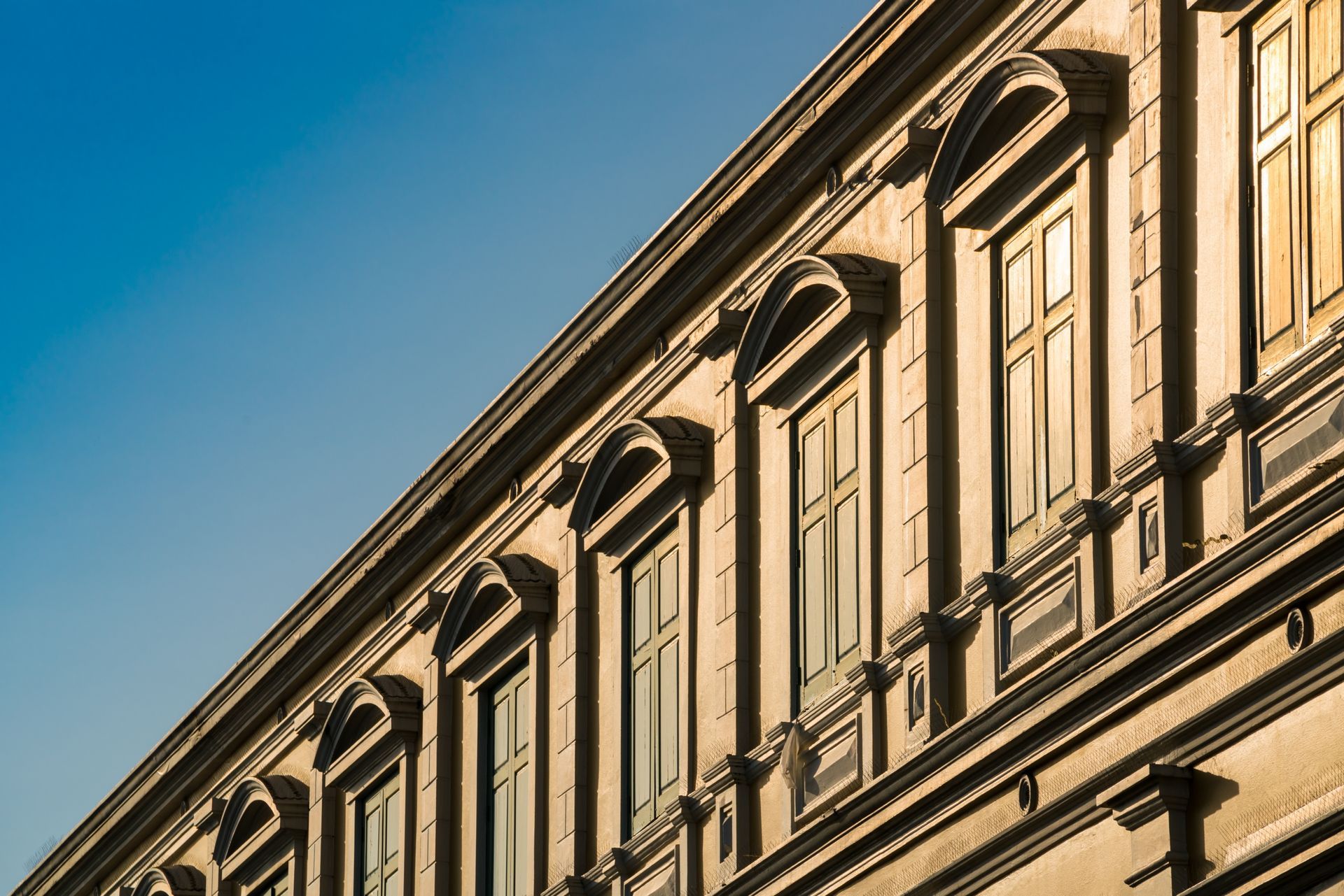 Un bâtiment avec beaucoup de fenêtres et un ciel bleu en arrière-plan