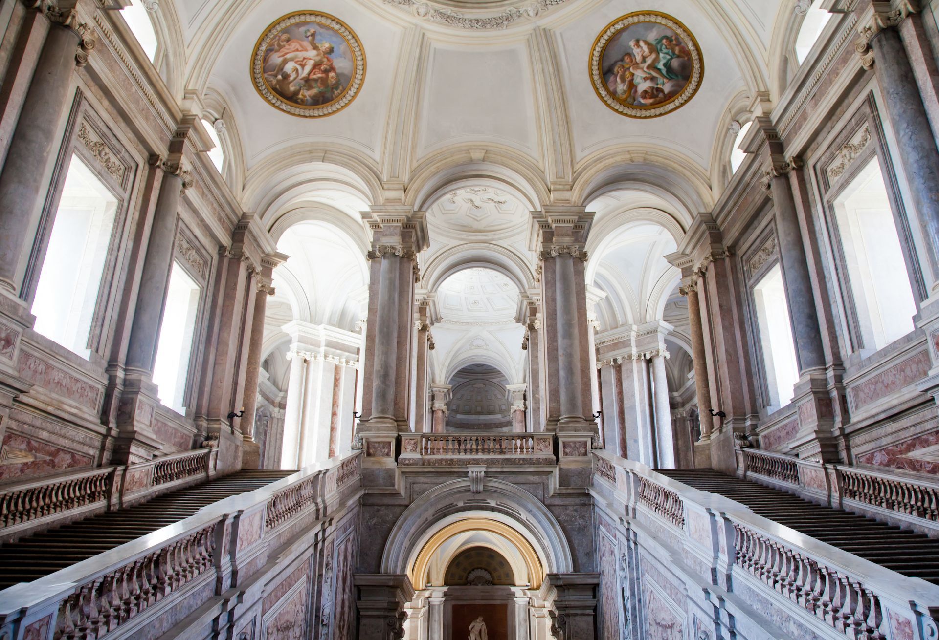 Un grand bâtiment avec des escaliers et un dôme au plafond.