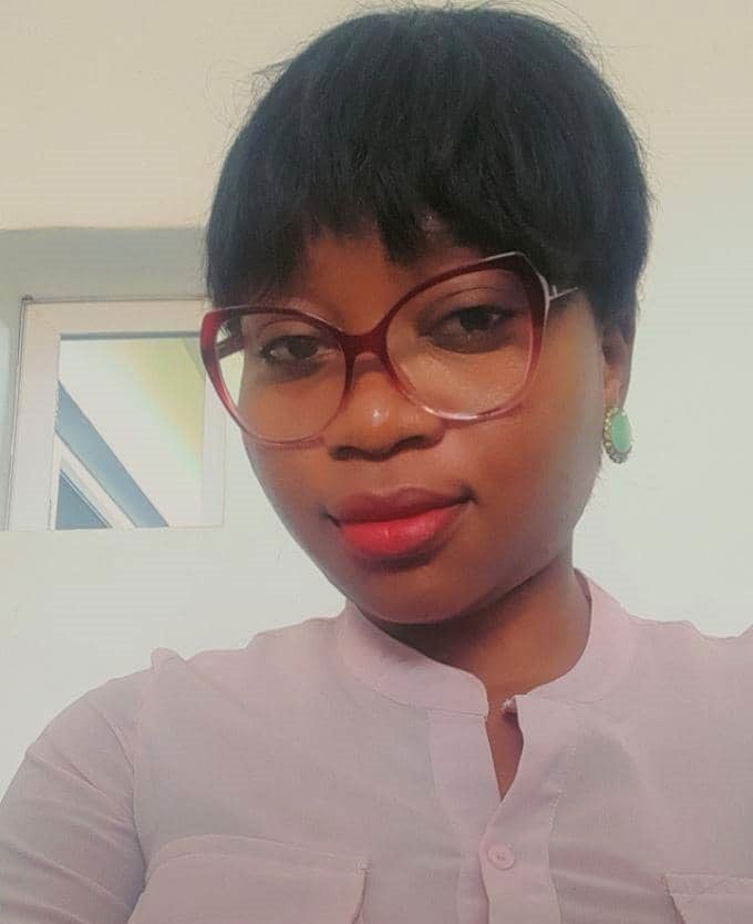 Une femme portant des lunettes et des boucles d'oreilles prend un selfie.