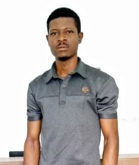 Un homme portant un polo gris se tient devant un tableau blanc.