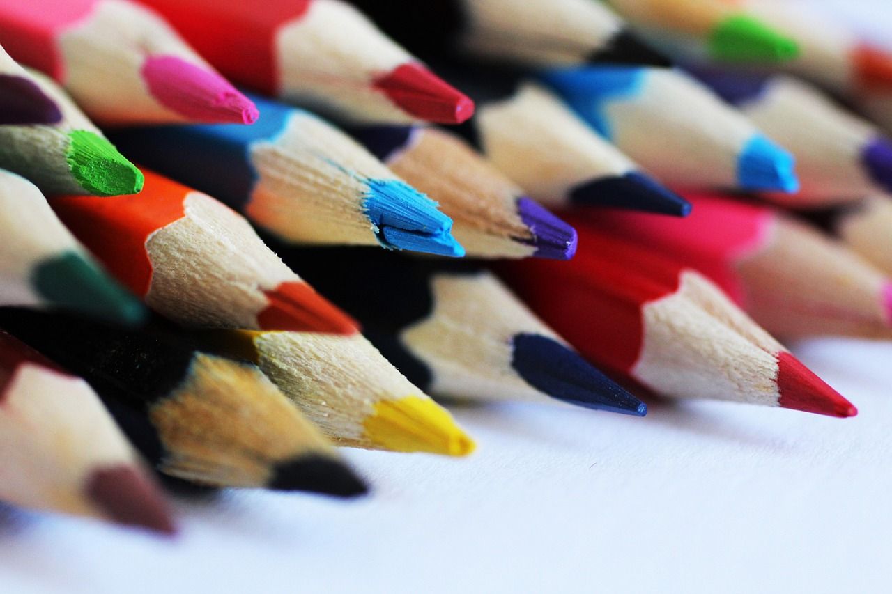 Primer plano de lápices de colores, con las puntas hacia la derecha; varios colores, incluidos rojo, azul, verde y amarillo.
