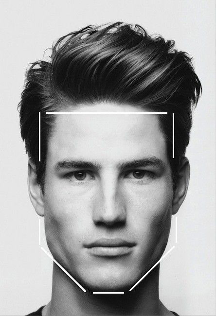 Hombre con cara cuadrada, delineada en blanco, cabello peinado hacia arriba.