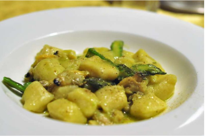una ciotola bianca piena di gnocchi e fagiolini