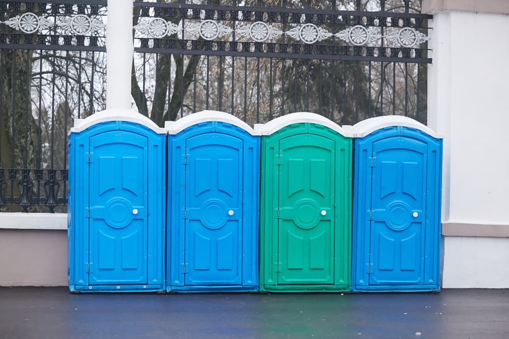 A Row of Blue and Green Portable Toilets Covered in Snow — Tony Gordon Septic Tank Cleaning in Bellingen, NSW