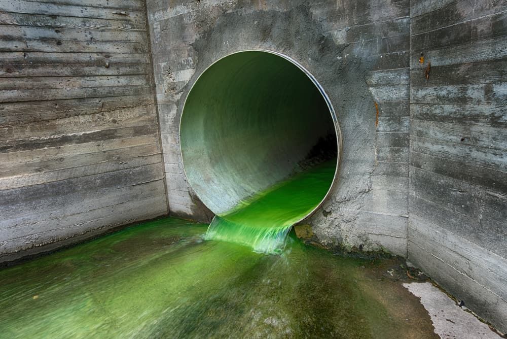 A Green Liquid is Coming Out of a Pipe in a Tunnel — Tony Gordon Septic Tank Cleaning in Newee Creek, NSW