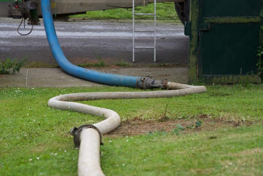 A Hose is Being Used to Pump Water Into a Tank — Tony Gordon Septic Tank Cleaning in Nambucca Heads, NSW