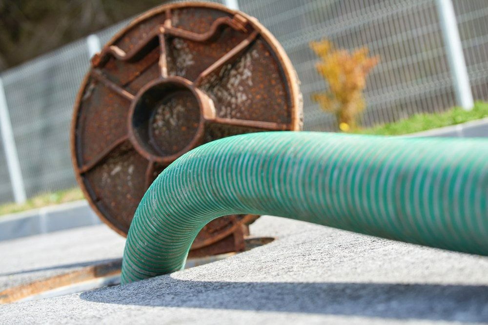 A Green Hose is Connected to a Rusty Pipe — Tony Gordon Septic Tank Cleaning in Newee Creek, NSW