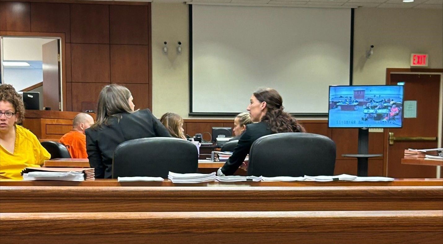A group of people are sitting at a table in a courtroom.