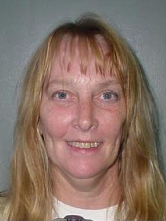 A woman with long blonde hair is smiling for the camera.