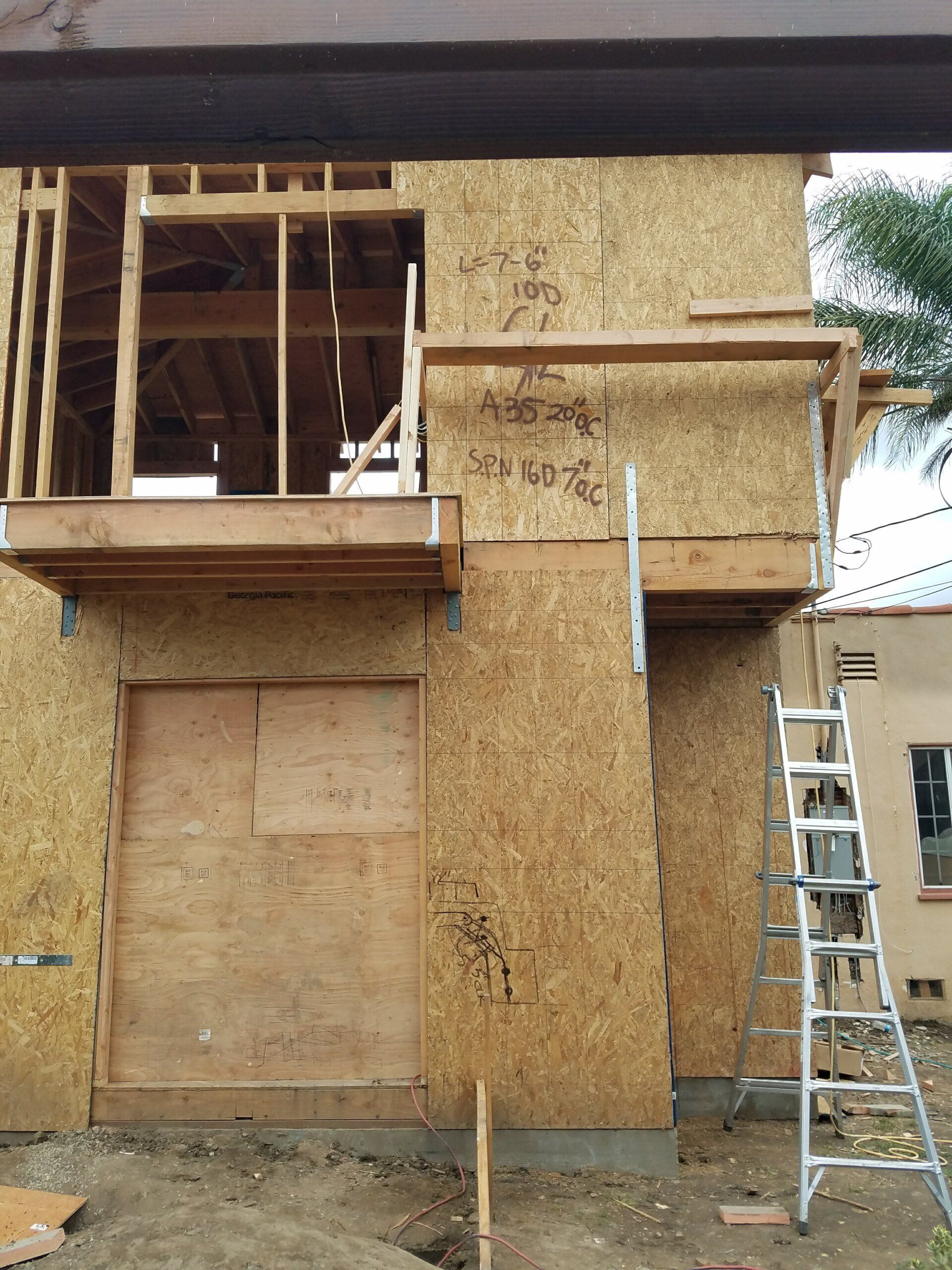 A ladder is on the side of a building under construction
