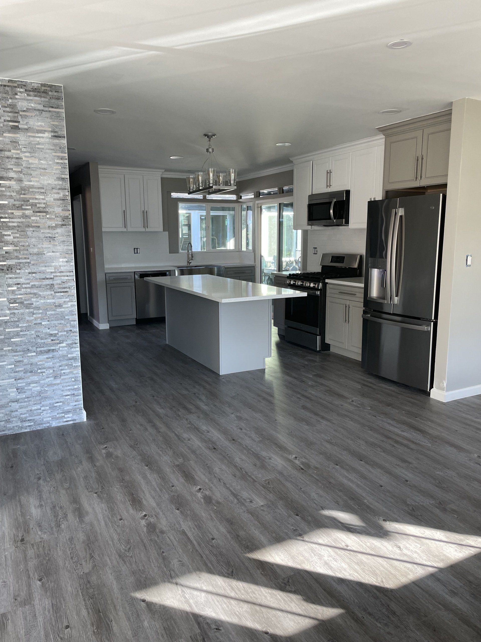 A kitchen with stainless steel appliances and a large island in the middle.