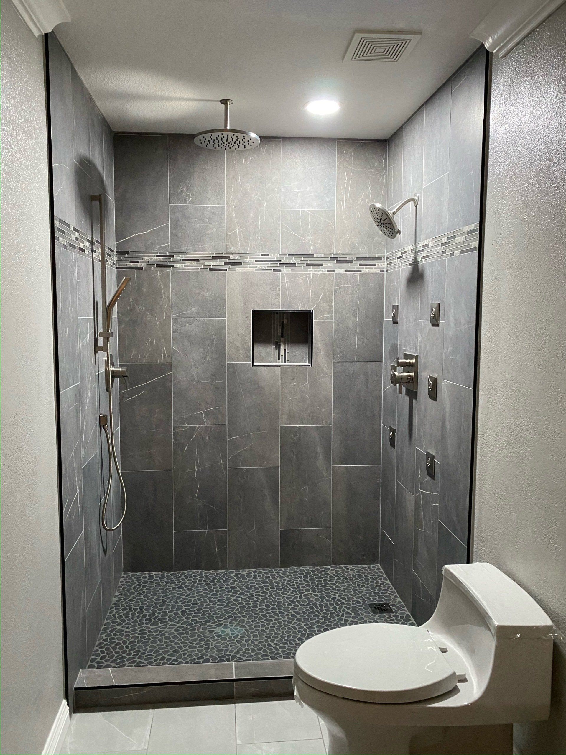 A bathroom with a toilet and a walk in shower.