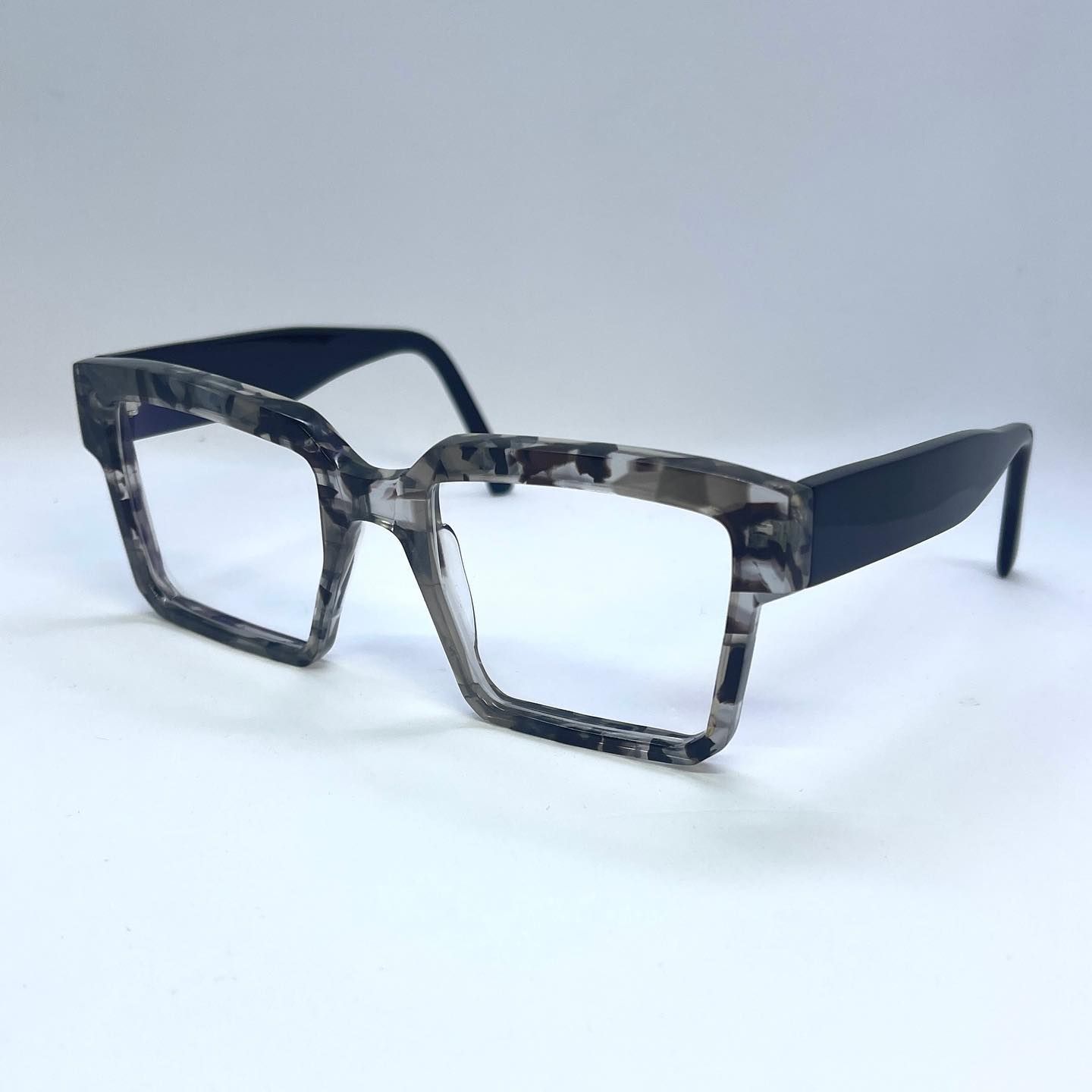 A pair of blue and gray glasses are sitting on a white surface.