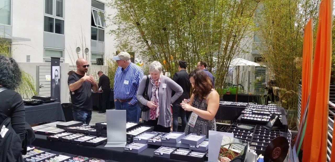 3 people standing outside viewing frames at Raise Your Glasses 2019 Event