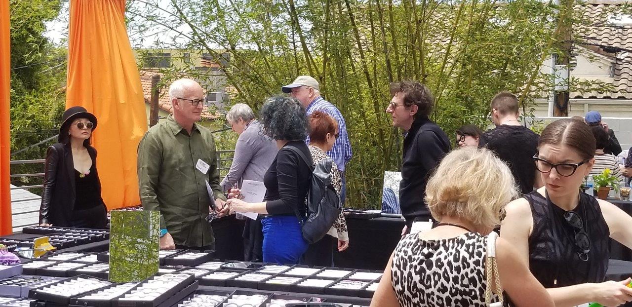 People standing outside looking at  frames at Raise Your Glasses 2019 Event