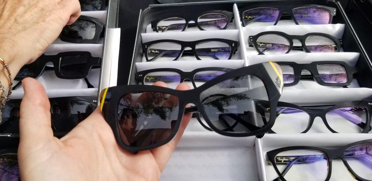 Hand holding a black sunglass frame at Raise Your Glasses 2019 Event