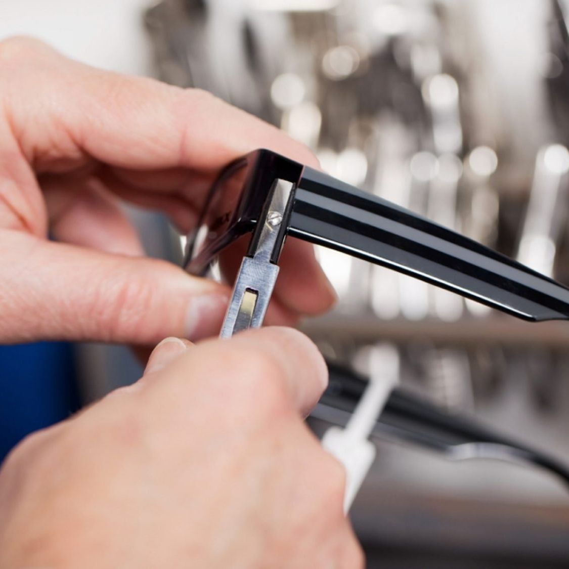 Person using small tool to adjust eyewear