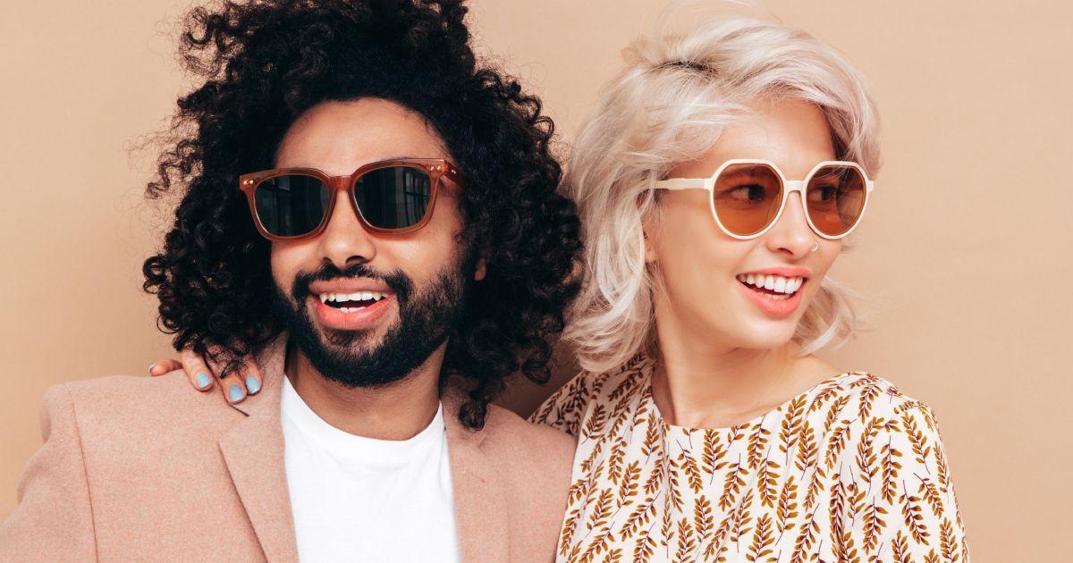 A man and a woman wearing sunglasses are posing for a picture.