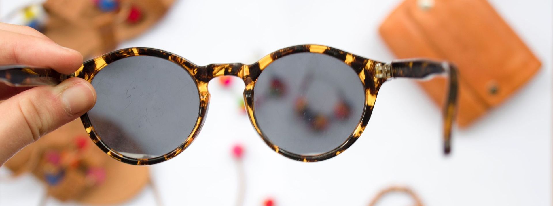 Close up of a persons finger holding a pair of glasses