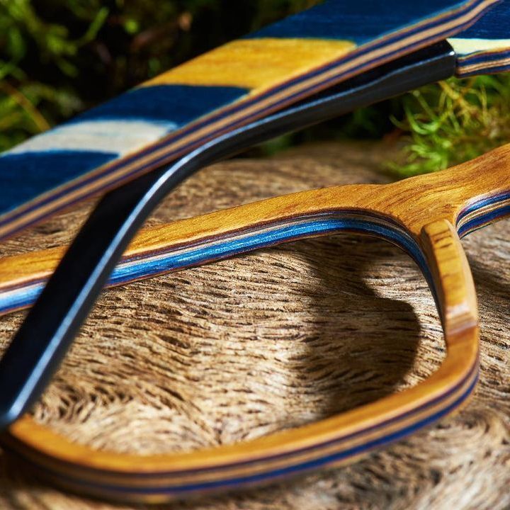 A pair of wooden glasses sitting on top of a piece of wood