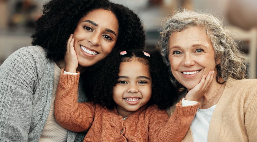 A grandmother, mother and child posing for a picture together