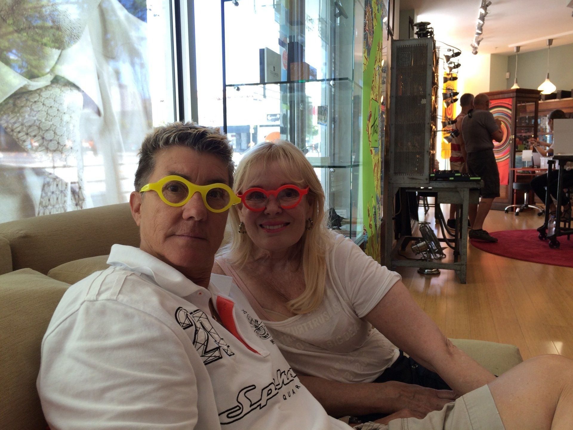 Two people wearing colorful glasses at Theo Trunk Show event at Urban Optiks