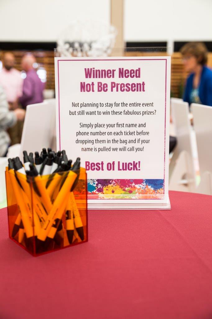 Sign with drawing info and container with pens at 2018 Raise Your Glasses