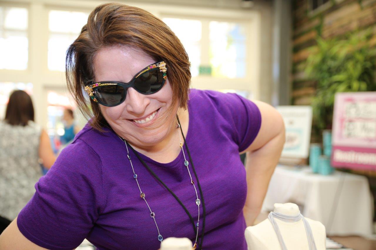 Person in purple blouse modeling sunglasses at 2018 Raise Your Glasses