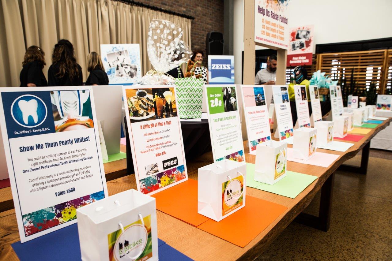 Banners and shopping bags with drawing prize info at 2018 Raise Your Glasses