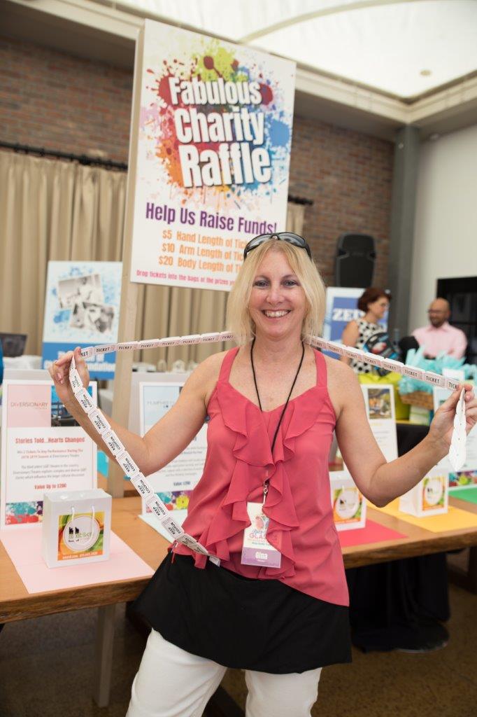 Person with drawing tickets around her neck standing inside at Raise Your Glasses 2018 Event