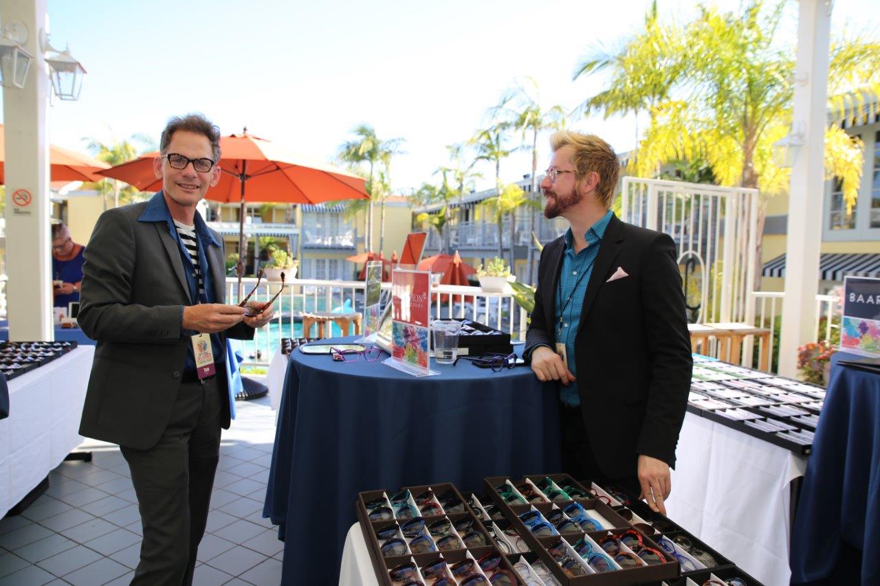 Vendor talking with guest at outdoor table at Raise Your Glasses 2018 Event