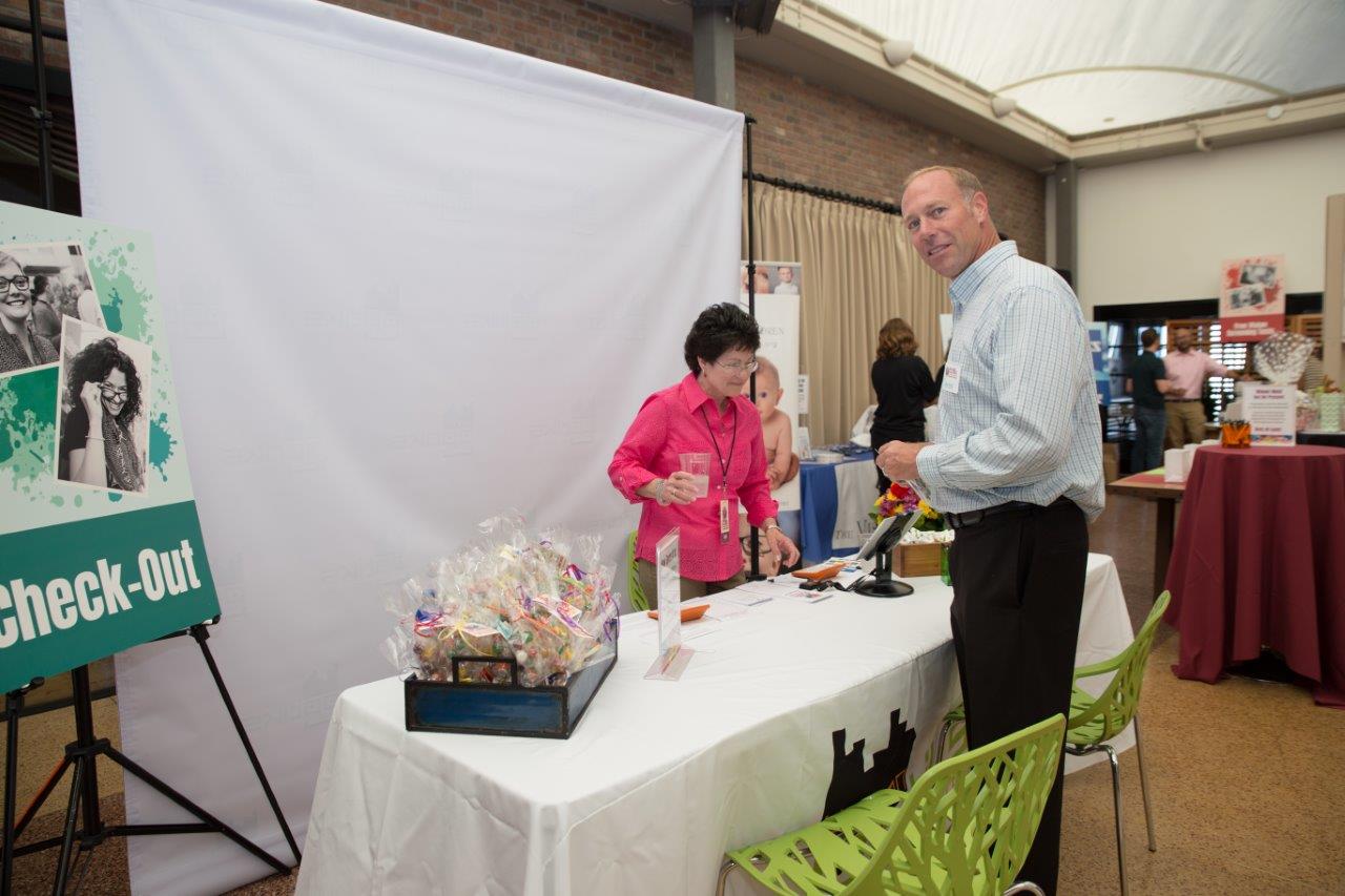 Attendee at check-out table at Raise Your Glasses 2018 Event