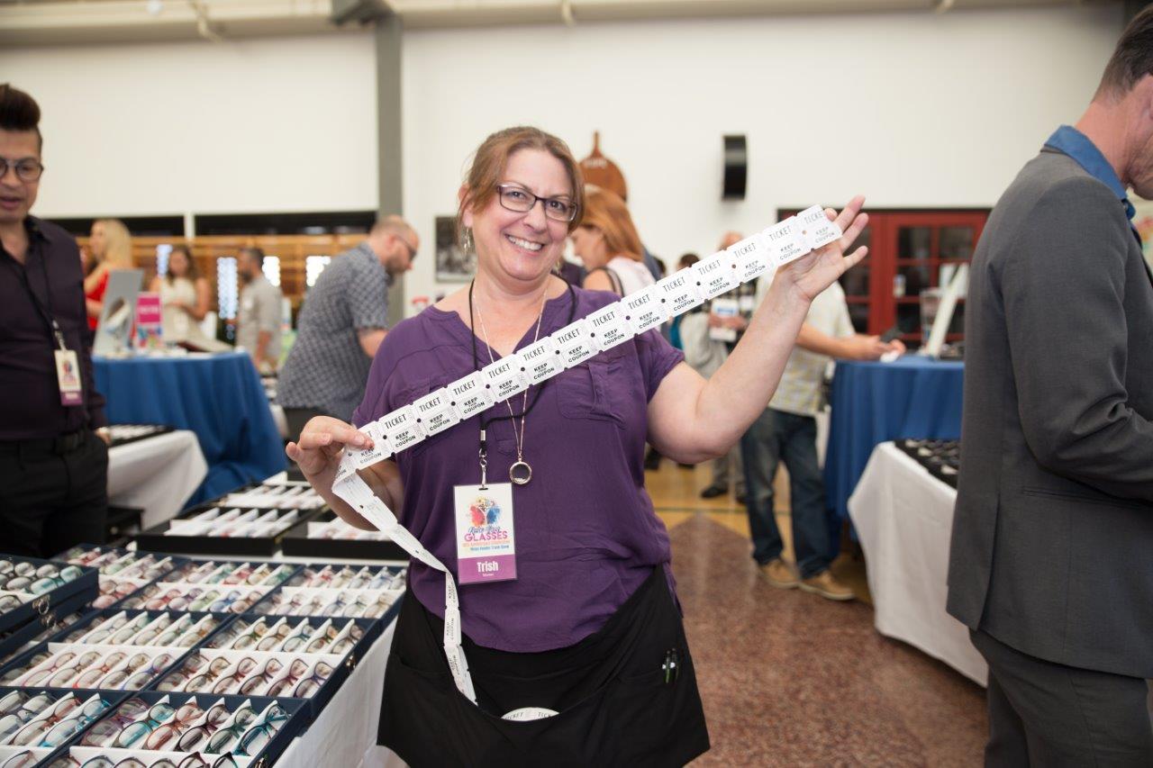 Person smiling and holding long strand of drawing tickets at Raise Your Glasses 2018 Event
