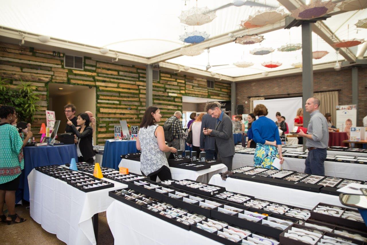 More shoppers looking at frame selections in display boxes during Raise Your Glasses 2018 Event