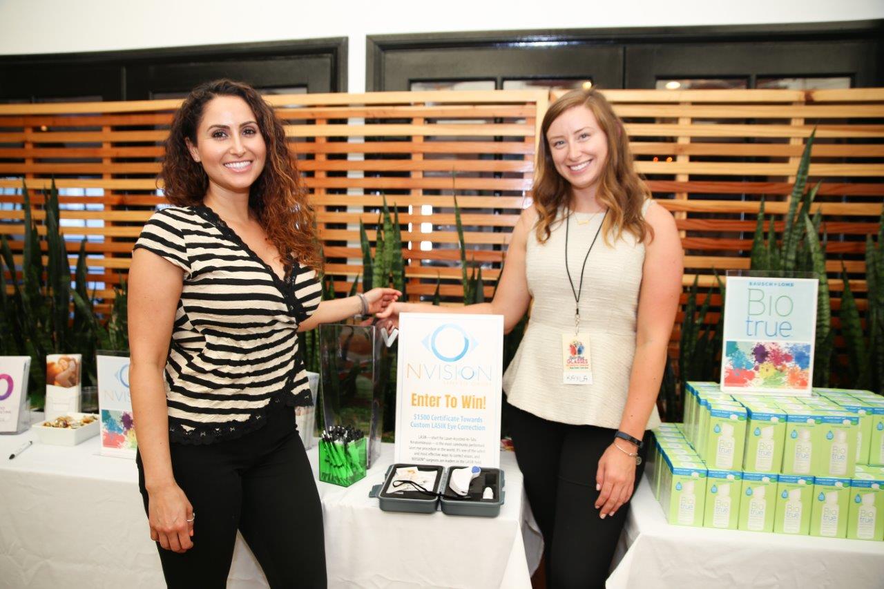 2 people showing off tabletop display at Raise Your Glasses 2018 Event