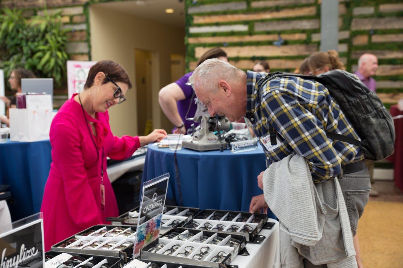 Vendor and guest looking at frame selections at Raise Your Glasses 2018 Event