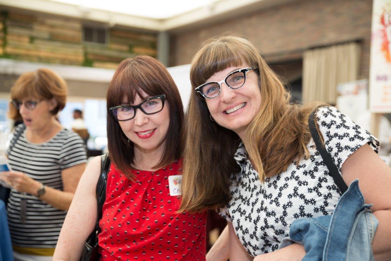 2 people smiling and wearing colorful glasses at Raise Your Glasses 2018 Event