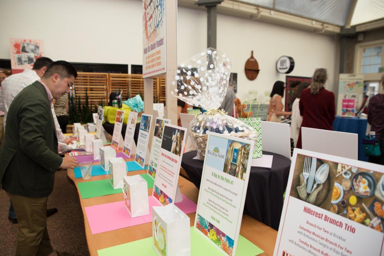 Tabletop display of small shopping bags with drawing prizes at Raise Your Glasses 2018 Event