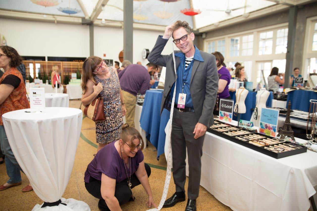 2 people holding a long strand of drawing tickets at Raise Your Glasses 2018 Event