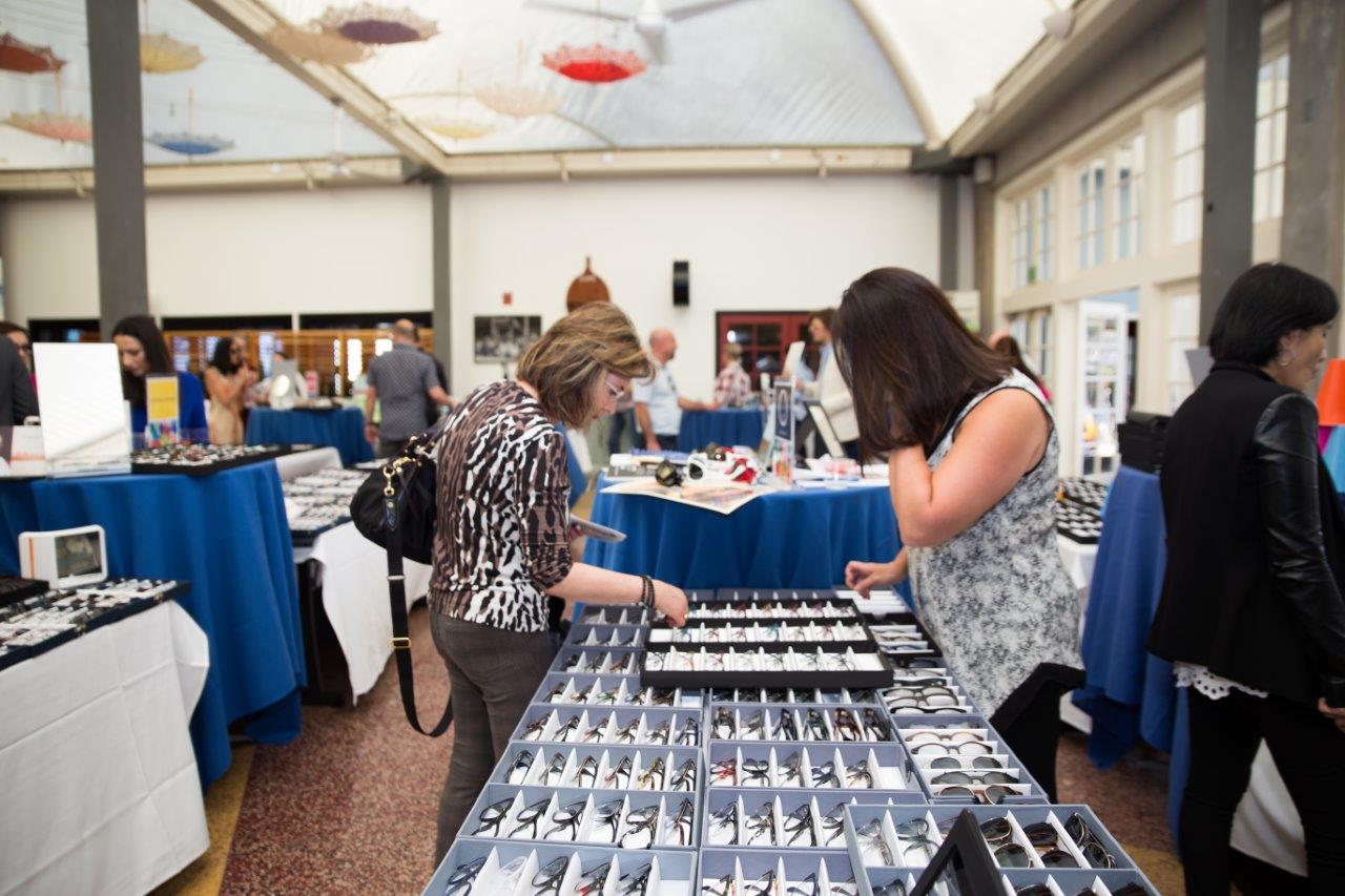 Shopper working with vendor at tabletop  frameline display at Raise Your Glasses 2018 Event