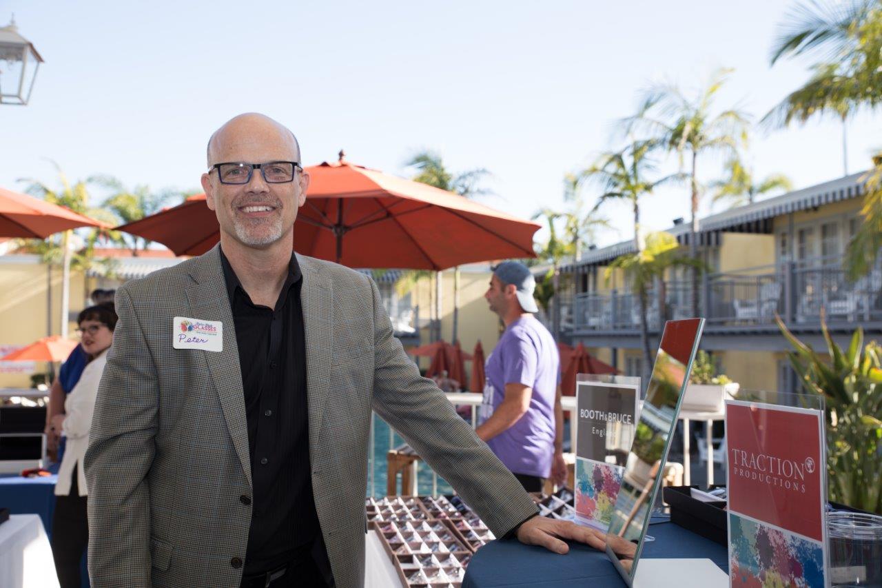 Vendor standing next to tabletop display of frames at Raise Your Glasses 2018 Event